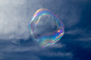 Giant colourful bubble with light clouds and blue sky, no people, family fun, summer.
