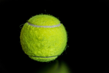 fuzzy green tennis ball on black background