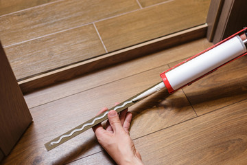 The apartment is under construction and renovation. Construction worker fixing metal profile to the...