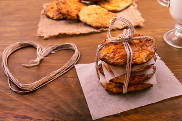 Delicious dessert of round cookies, tied with a harsh thread, laid on a paper napkin, wooden background.