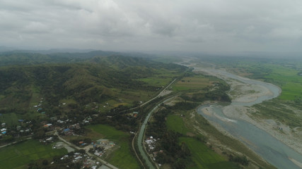 Fototapeta na wymiar Mountain valley with river, farmland in the Philippines, Luzon. Aerial view of mountains covered forest, tree. Cordillera region.