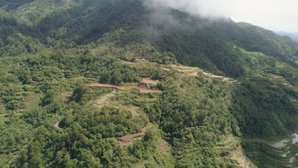 Aerial view of rice terraces on the slopes of the mountains, Banaue, Philippines. Rice cultivation in the North Batad. Mountains covered forest, trees. Philippine Cordilleras.