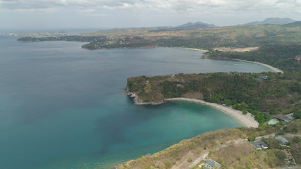 Aerial view of seashore with beach, lagoons and coral reefs. Philippines, Luzon. Ocean coastline with turquoise water. Tropical landscape in Asia.