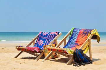 Fototapeta na wymiar sun beach chairs on shore near sea