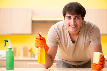 Single man cleaning kitchen at home