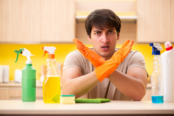 Single man cleaning kitchen at home