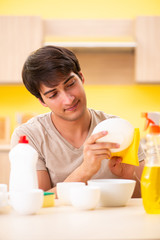 Obraz na płótnie Canvas Man washing dishes at home