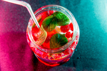 Summer drink coctail in glass jar, berries and mint on wooden table