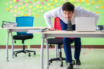 Man in the office with many conflicting priorities doing exercis