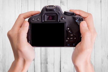 Hands holding the camera on wood background,include clipping path