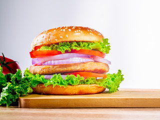 The hamburgers with meat and vegetables putting in layer. It is the food of Westerners. Moreover, It is the easy food concept in every area.
