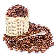 Coffee beans in a wicker basket With spoon on white background