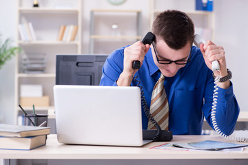 Young businessman employee working in office at desk  