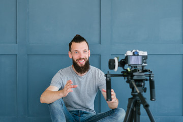 blogger streaming live. bearded hipster man communicating with subscribers through camera. new...