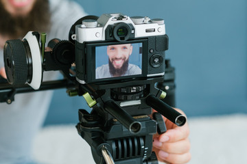 modern technology for photo and video shooting. camera on tripod. blogger equipment and tools. image of a man on screen.