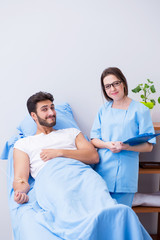 Woman doctor examining male patient in hospital