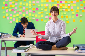 Man and woman in the office with many conflicting priorities in 