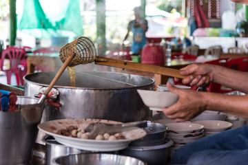 Chef cooking a noodle soup at street food market