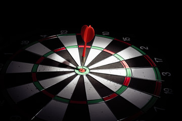 Obraz premium Target with arrow in the center on a black background