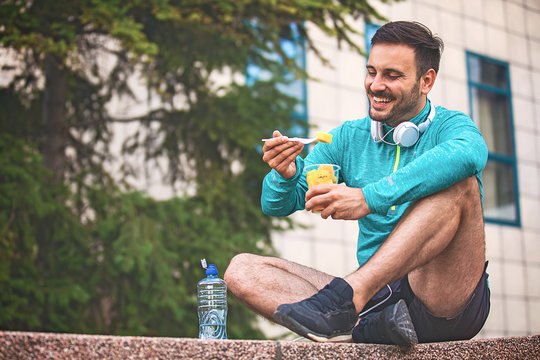 Man is eating fruit after morning workout