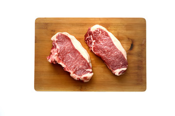 A fresh raw  marble beef on a cutting board on a white background.Top view.
