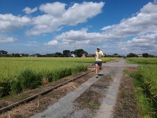 Man running on country trail with beautiful sky