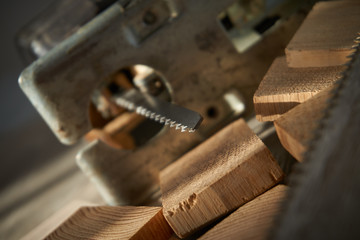Close up electric jigsaw blade and wooden bricks