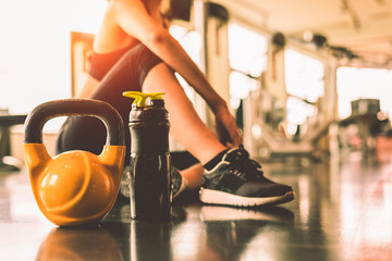 Fermez les kettlebells avec une séance d& 39 exercices pour femmes dans la salle de gym, détendez-vous après l& 39 entraînement sportif avec fond de bouteille de shake protéiné. Musculation de mode de vie sain et haltères de muscles d& 39 athlète.