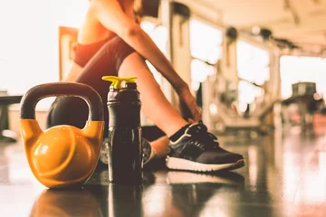 Papier Peint photo Fitness Fermez les kettlebells avec une séance d& 39 exercices pour femmes dans la salle de gym, détendez-vous après l& 39 entraînement sportif avec fond de bouteille de shake protéiné. Musculation de mode de vie sain et haltères de muscles d& 39 athlète.