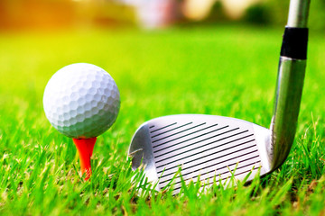 Golf ball and golf clubs on the Course. Golf ball on Orange tee. They are prepare to shot. Photo for health and game. 