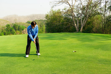 Man playing golf on a golf course.