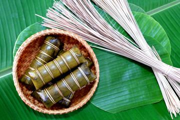 Glutinous rice steamed in banana leaf in bamboo bowl.