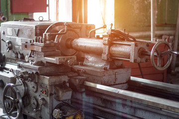 Old lathe at the enterprise, a sunset comes through the window, workshop