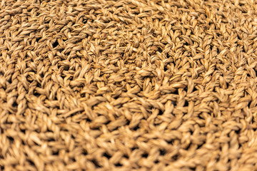 Texture closeup of a circular weaving of straw, focus with shallow depth of field, blurred background
