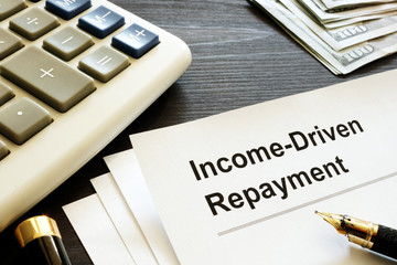 Income Driven Repayment. Papers, calculator and money.