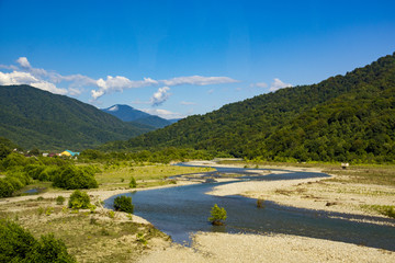 mountain river on a background of mountains and blue sky