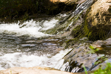 a stormy stream of water flows between the rocks