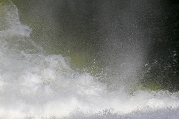 Splashes and spray from waterfall. Big water splash in lake after diving. Splash water on the...