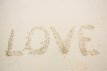 writing love on sand. love message written in sand