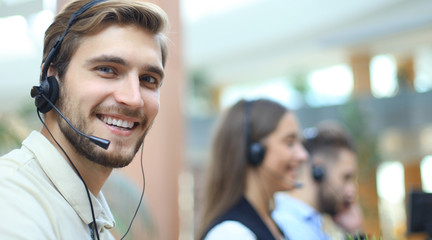 Attractive positive young businesspeople and colleagues in a call center office.