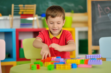 A boy in the children's room playing at the table