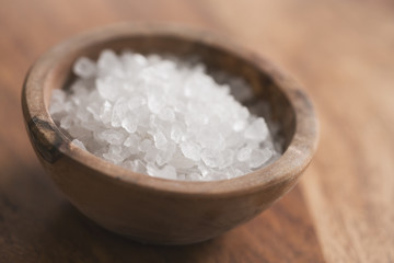 Sea salt in bowl on wood table