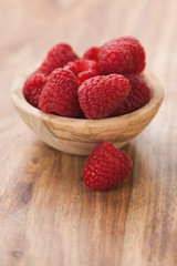 fresh raspberries in wood bowl on table with copy space
