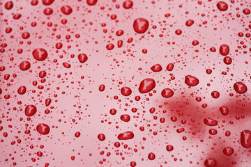 Closeup rain drops on red car with hydrophobic coating