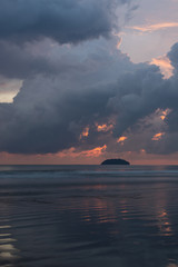 Island on the horizon at sunset on the South China Sea.