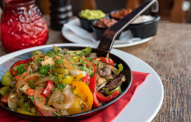 Mexikanisches Essen Fajita mit Rinder Fleisch und Gemüse in einer Eisen Pfanne gebraten mit Weizen Tortillias
