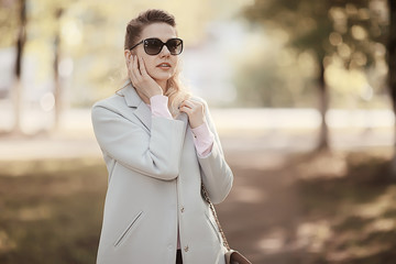 portrait of a european beautiful female model wearing sunglasses / girl outdoors walking, happy cheerful girl wearing glasses