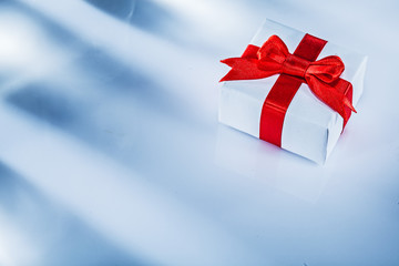 Red present box with tied bow on white background