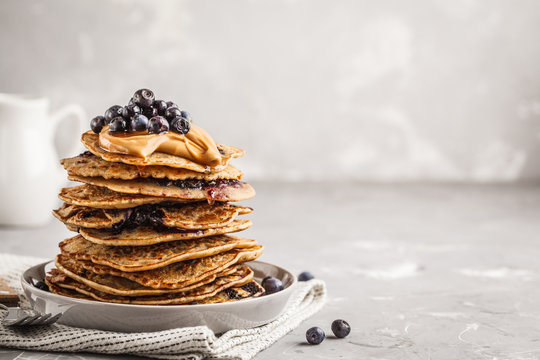 Stack Vegan Blueberry Pancakes With Peanut Butter And Syrup.