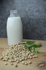 Pouring bio soy milk on rustic wood dark background